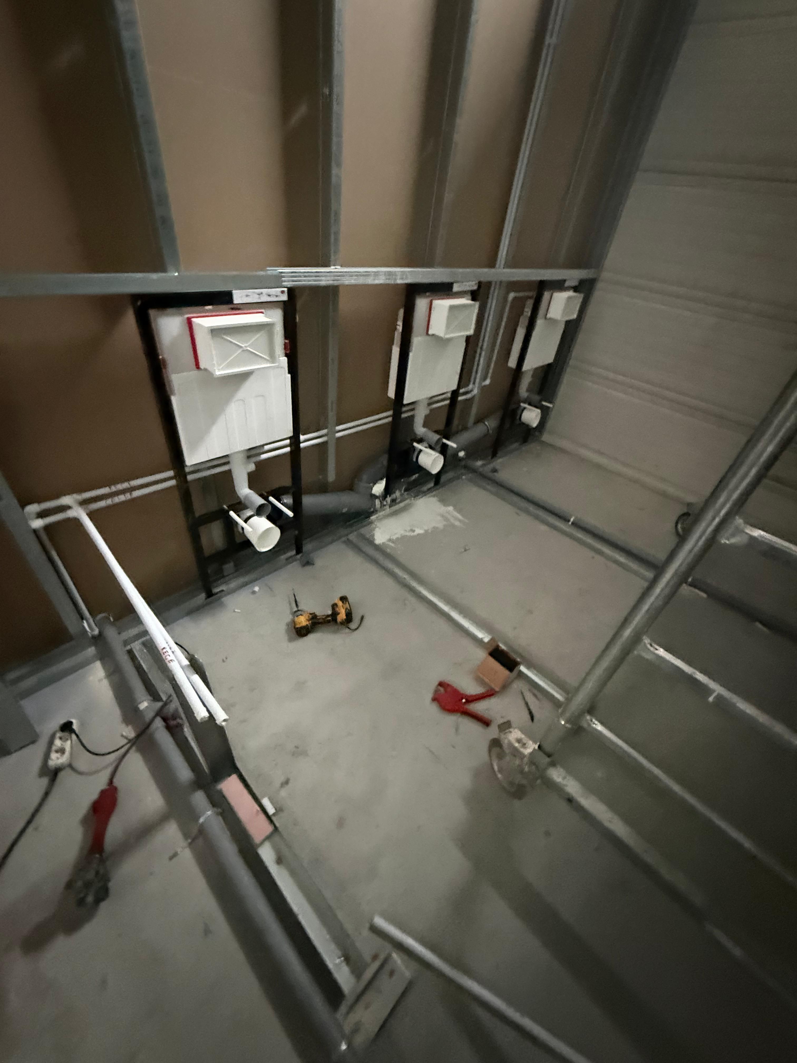 Grup sanitar în execuție, cu instalații și rezervoare încastrate în structura de gips carton